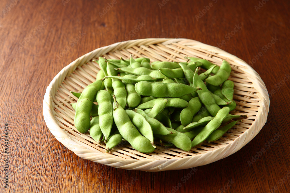 笊に盛った生の枝豆 木目背景 笊に盛った生の枝豆 木目背景