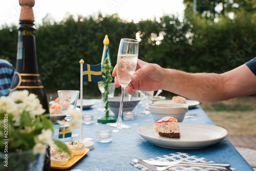 man holding champagne glass celebrating midsummer in Sweden