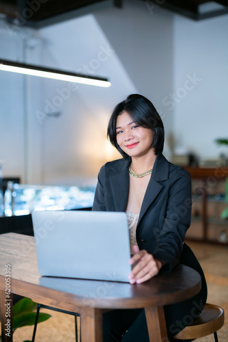 Portrait of asian freelance people businesswoman casual working with laptop computer in cafe interior in coffee shop background,business expressed confidence embolden and successful concept