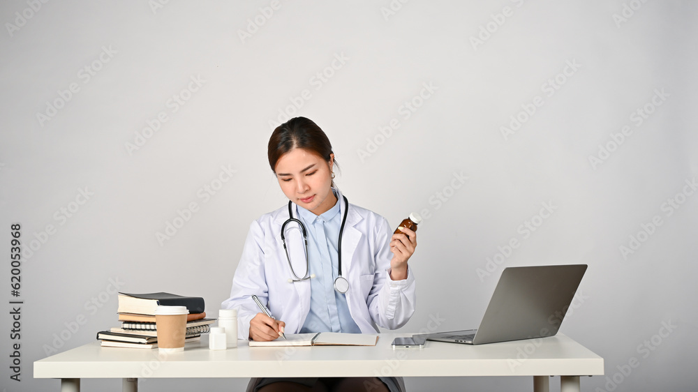 Young female Asian doctor working in her clinic room, whited isolated background. Young female Asian doctor working in her clinic room, whited isolated background.