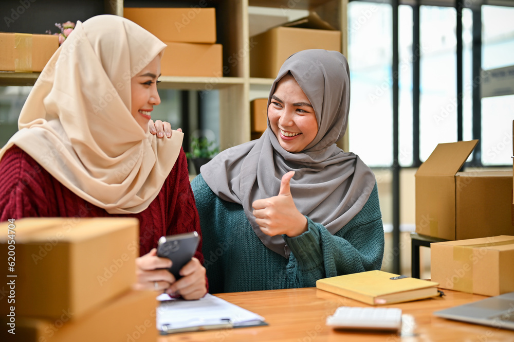 Young muslim online business team working together, showing a thumbs up sign. Young muslim online business team working together, showing a thumbs up sign.