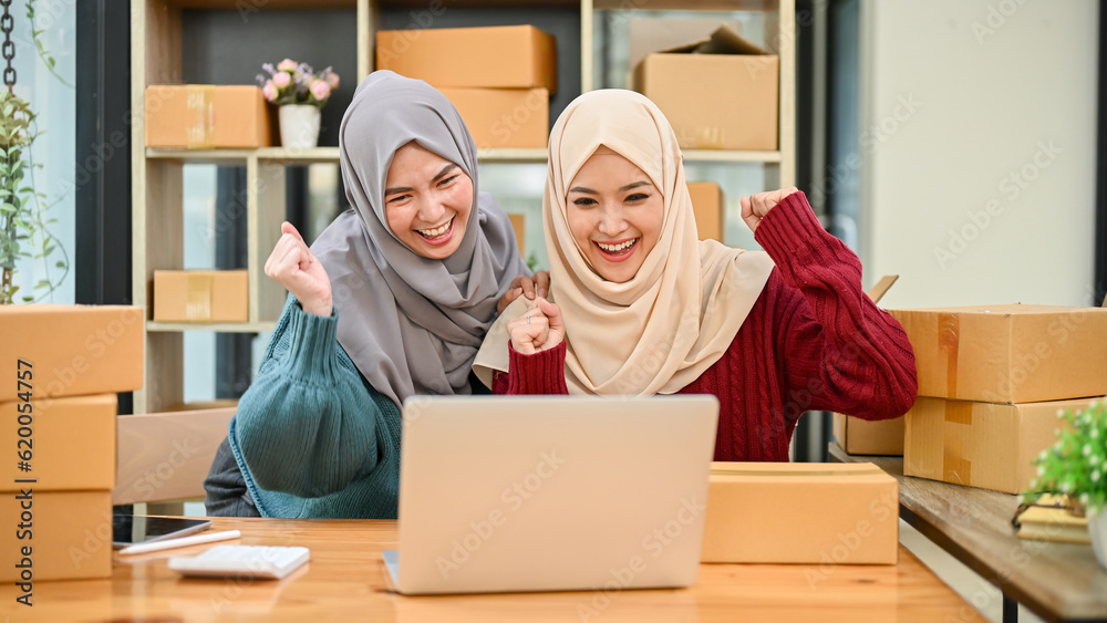 Muslim team of online business celebrating after receiving big orders or getting good feedback Muslim team of online business celebrating after receiving big orders or getting good feedback