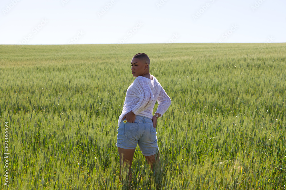 Non binary latin person and young gay man having fun in the green wheat field doing different back body postures. Concept of ecological agriculture, homosexuality and human rights.