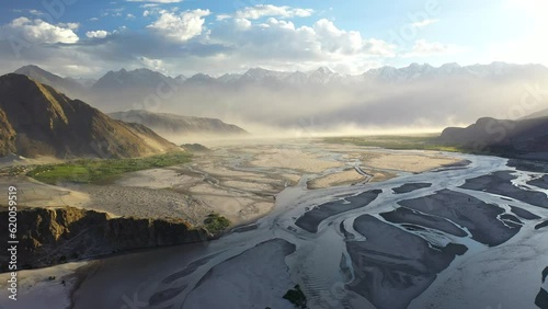 Cinematic aerial shot of Skardu Valley in Gilgit Baltistan, Pakistan. Wide slowing rotating, into the sun, and over water in the valley. Shigar and Indus River. Epic drone shot. photo
