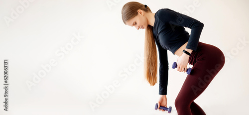 Slender female practicing romanian deadlift exercise in gym photo