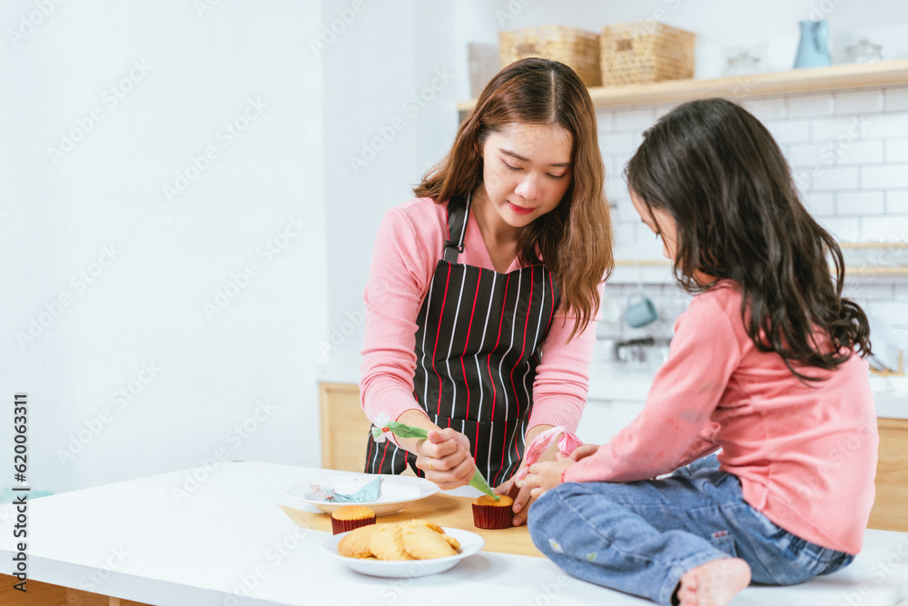 Blissful Mother-Daughter Duo Creating Sweet Memories through Cake Decoration Blissful Mother-Daughter Duo Creating Sweet Memories through Cake Decoration
