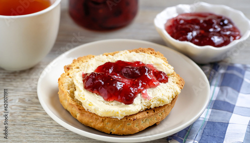Traditional british scones with clotted cream and strawberry jam for tea time