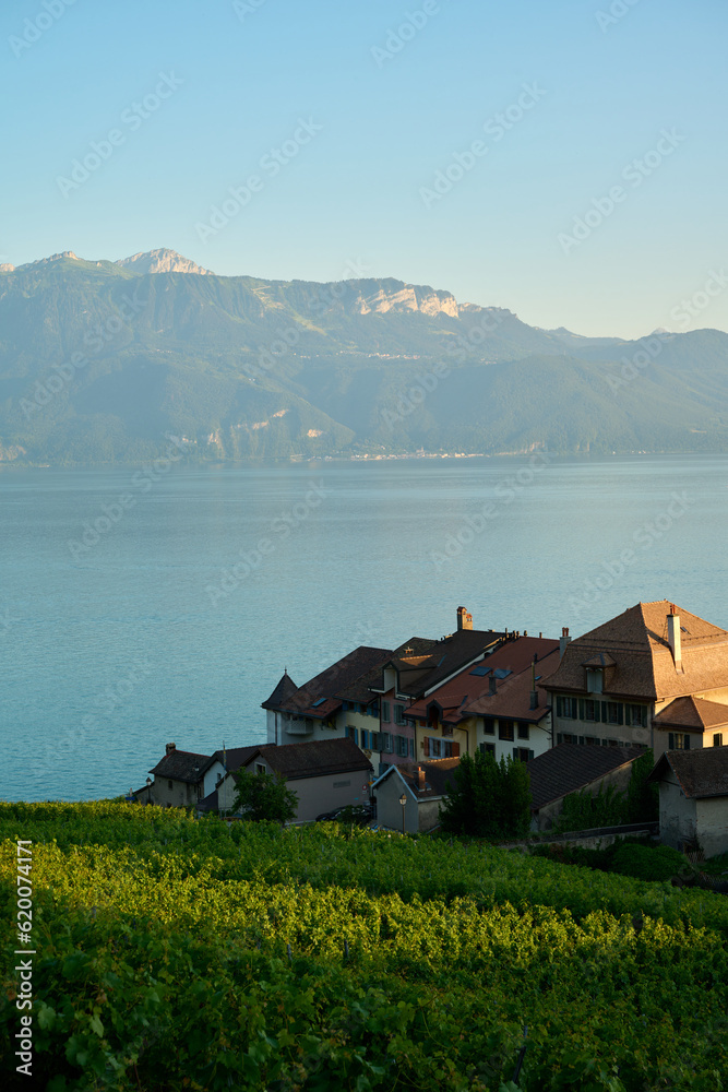 Village in Switzerland by lake and mountains in sunset