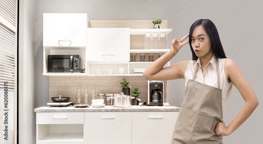enjoy asian woman with apron at kitchen carbinet at home on background enjoy asian woman with apron at kitchen carbinet at home on background