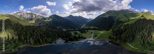 Montriond lake seen from above. Aerial of French Alps mountain range and leisure melt water pond during summer. photo