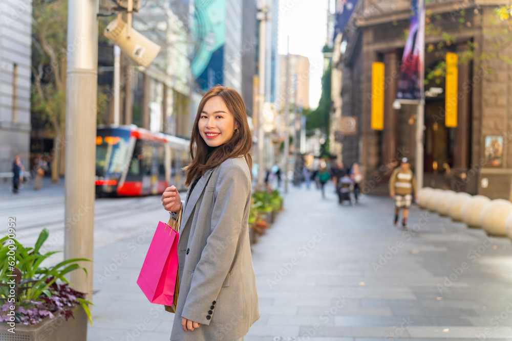 Portrait of Happy Asian woman holding shopping bag walking and shopping in the city together. Attractive girl enjoy and fun urban outdoor lifestyle walking and travel city street on holiday vacation. Portrait of Happy Asian woman holding shopping bag walking and shopping in the city together. Attractive girl enjoy and fun urban outdoor lifestyle walking and travel city street on holiday vacation.