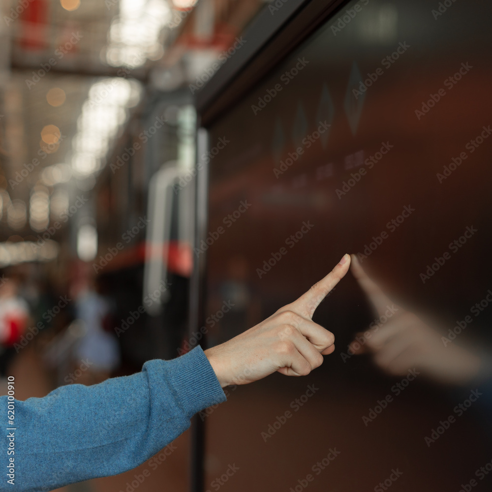 man uses interactive modern touch screen monitor, information kiosk