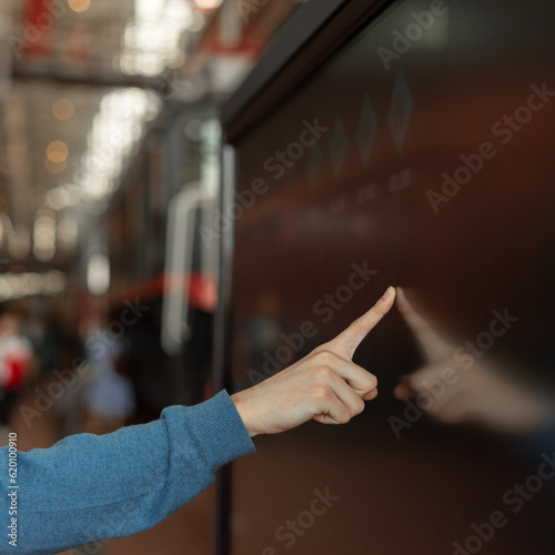 man uses interactive modern touch screen monitor, information kiosk