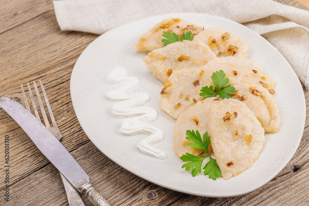 Dumplings, filled with cabbage. Fried onion, fresh sour cream. Traditional Ukrainian dish Dumplings, filled with cabbage. Fried onion, fresh sour cream. Traditional Ukrainian dish