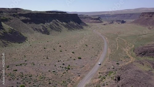 Aerial tracking vehicle rotates to reveal scablands canyons, coulees photo