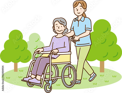 屋外でシニア女性が乗る車を押して歩く若い女性介護士