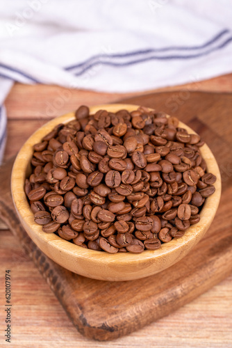 Coffee bean on wood background. Coffee bean in wooden bowl. Close up