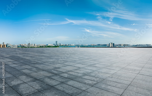 Empty square floor and city skyline with modern buildings under the blue sky