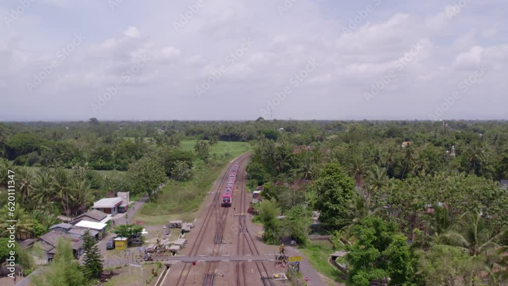Drone follows red train at Jogjakarta Indonesia during day time, aerial Drone follows red train at Jogjakarta Indonesia during day time, aerial