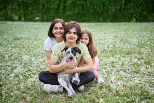 Support, care or happy family, woman and kids bonding with foster puppy or pet and enjoying time together. High quality photo