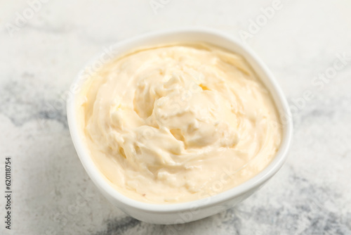 Bowl with tasty cream cheese on white marble background