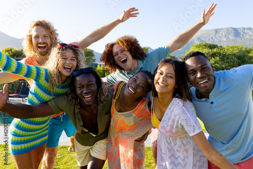Portrait of happy diverse group of friends having party, smiling in garden