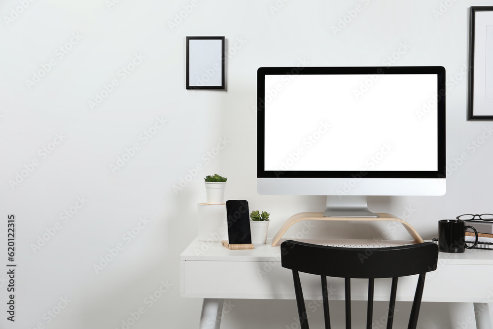 Cozy workspace with computer, smartphone and stationery on wooden desk at home Cozy workspace with computer, smartphone and stationery on wooden desk at home