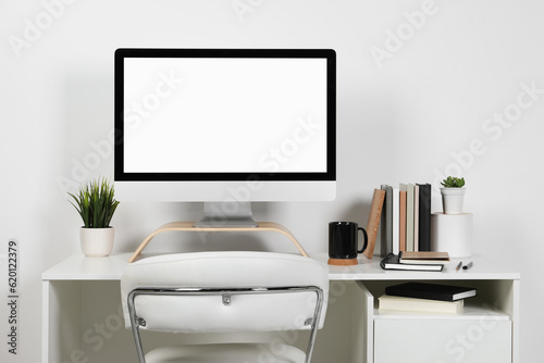 Cozy workspace with computer and stationery on wooden desk at home