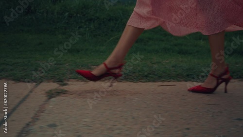 Women's feet in red shoes are going