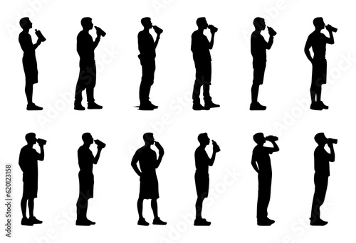 silhouette of man standing drinking water from bottle