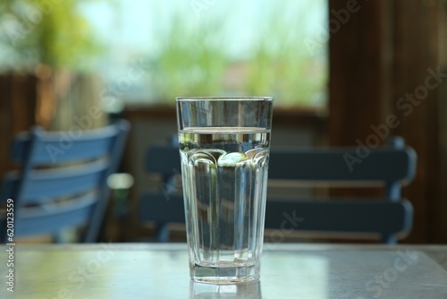 Glass of fresh water on table indoors