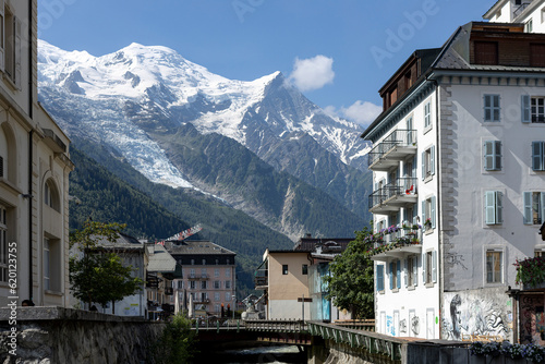 Eternal snow on the Mont Blanc massive rising above the buildings of ski village Chamonix in the French Alps against a clear blue sky.