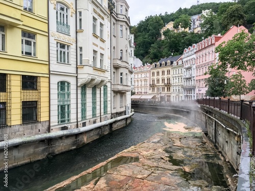 Tepla creek channel in Karlovy Vary with hot water from springs making steam at Vridelni street photo