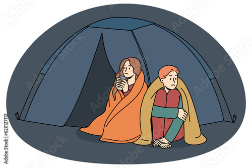 Confused man and woman sleeping in tent outside live for charity or donation. Unhappy couple refugees in camp on street. Homeless problem. Vector illustration.