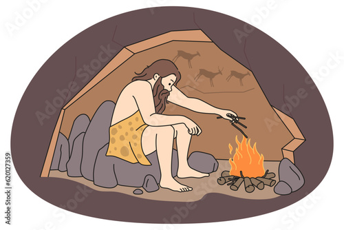Caveman sitting in cave near bonfire warming. Male prehistoric person making fire during ancient ages. Vector illustration.