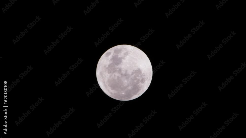 A zoomed in shot of the full moon from the southern hemisphere. Faint clouds can be seen passing in front of the moon at the start of the shot. Camera is stationary with moon slowly moving. A zoomed in shot of the full moon from the southern hemisphere. Faint clouds can be seen passing in front of the moon at the start of the shot. Camera is stationary with moon slowly moving.