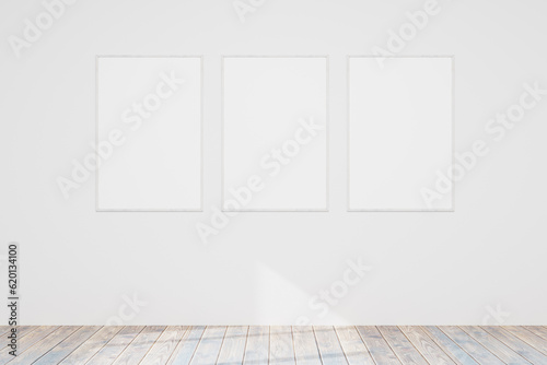 Three empty wooden photo or picture frames hang on a white wall. Wooden floor. Models of paintings  posters  photographs. Design template for layout. 3D rendering.