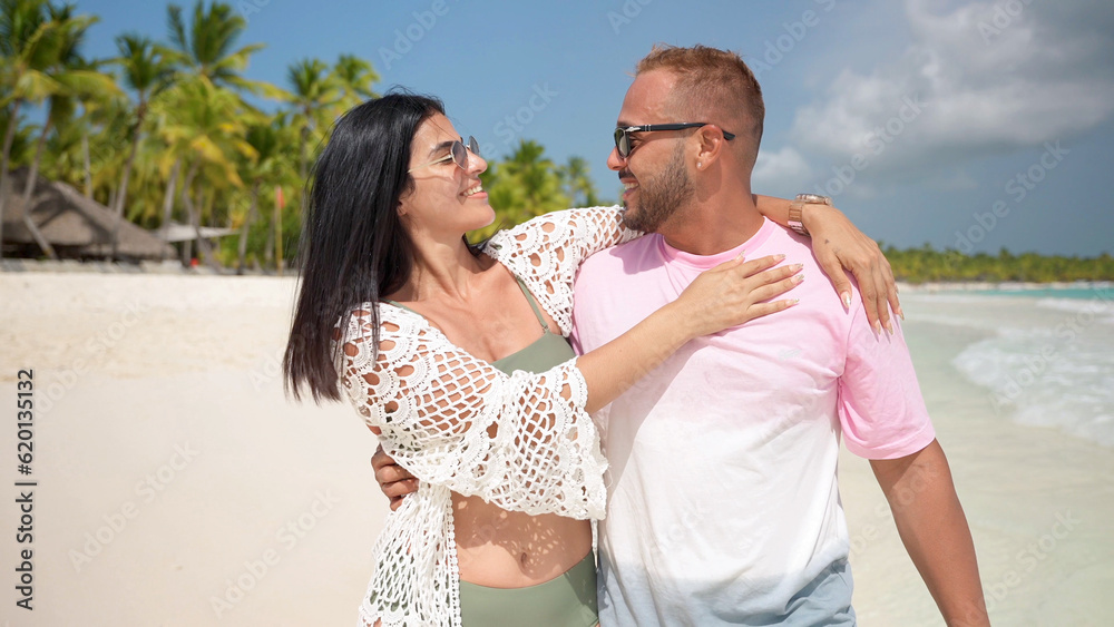 Latin american couple enjoys a vacation on the tropical beach. Turquoise water and white sand with palm trees. Latin american couple enjoys a vacation on the tropical beach. Turquoise water and white sand with palm trees.