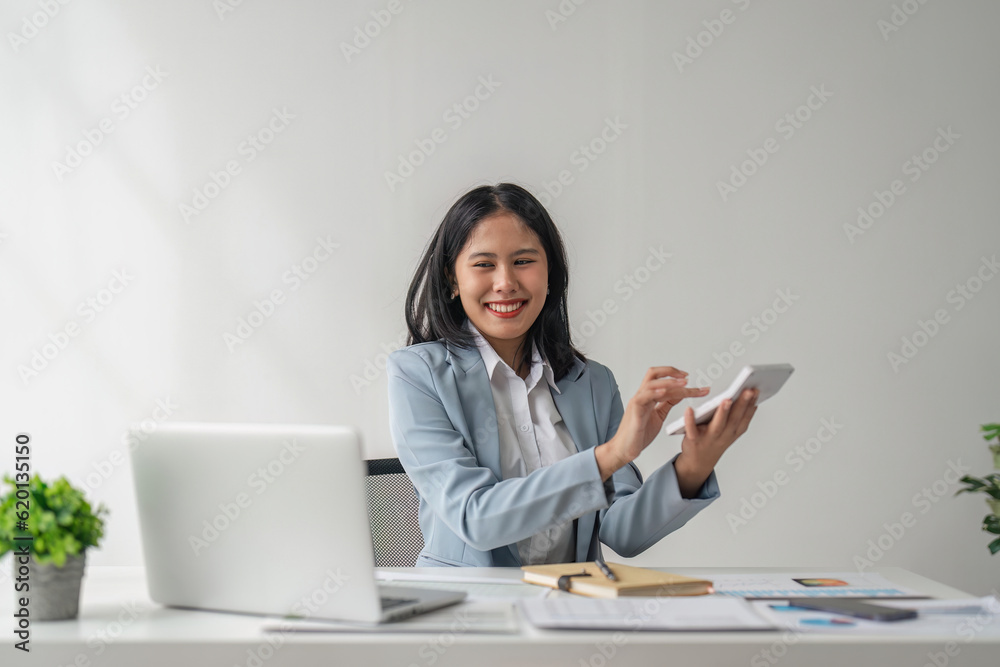 Asian business woman using a calculator calculating financial expense at office, press calculator button finance analyzing Asian business woman using a calculator calculating financial expense at office, press calculator button finance analyzing