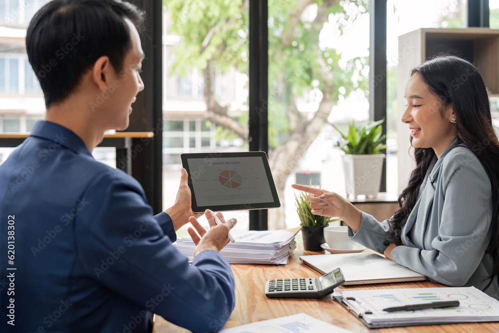Happy businesspeople working together in the office while using laptop analyze the company finances and tax Happy businesspeople working together in the office while using laptop analyze the company finances and tax