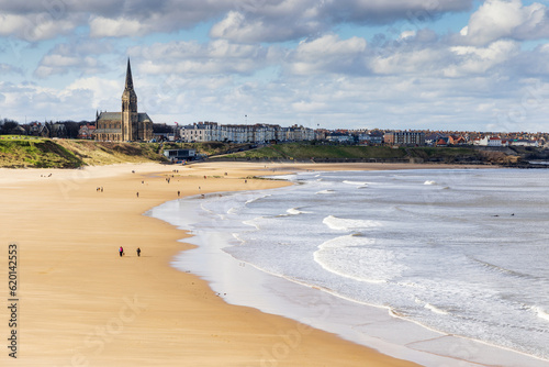 Long Sands beach at Tynemouth on a bright spring day, with St George's church at Cullercoats in the distance, Tyne and Wear. photo