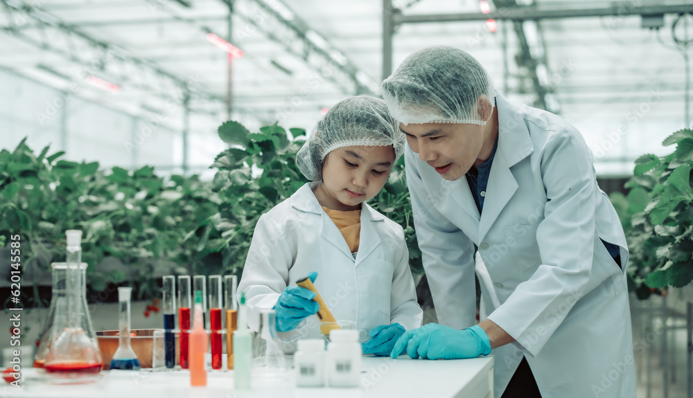 A scientist father guides his daughter in farming using a pH meter. Measuring acid-base levels in water to ensure right conditions for strawberry growth. Combining expertise with technological tools. A scientist father guides his daughter in farming using a pH meter. Measuring acid-base levels in water to ensure right conditions for strawberry growth. Combining expertise with technological tools.