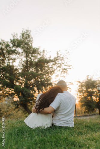 Portrait of amorous adorable cheerful couple spouses hugging sitting enjoying weekend fresh air outdoors. The concept of a happy relationship in marriage. No focus blurred and noise effect