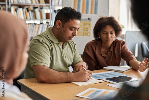 Group of multiethnic students learning foreign language together in class