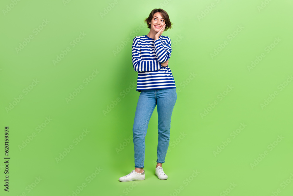 Full body brown hair model girl photo of touch cheek look empty space satisfied thoughts about new brand isolated on green color background Full body brown hair model girl photo of touch cheek look empty space satisfied thoughts about new brand isolated on green color background