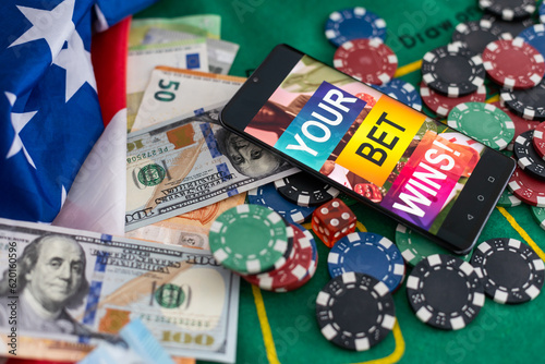 Smartphone with poket table on screen, playing cards and chip cards on poker table. Online casino. photo