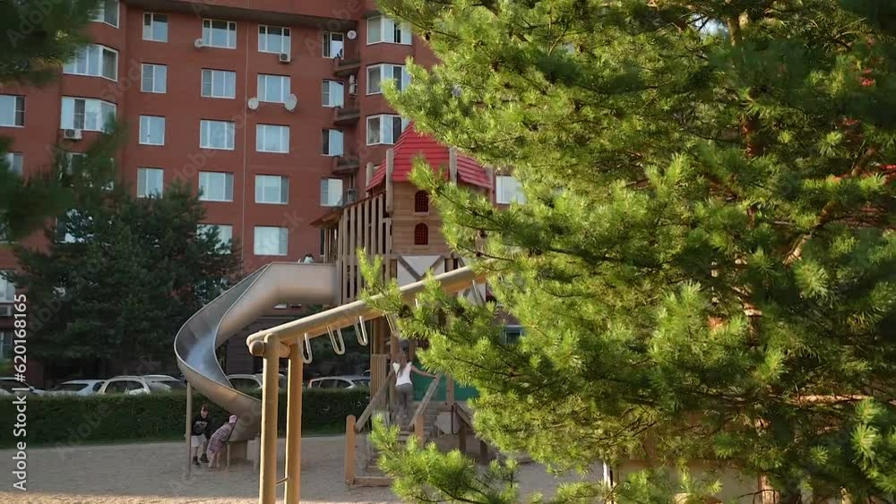 A modern playground in an ecological green residential complex in the summer. Dolly camera A modern playground in an ecological green residential complex in the summer. Dolly camera