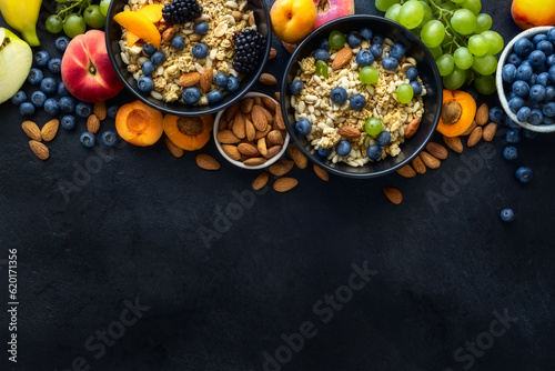 Two healthy breakfast bowl with ingredients granola fruits greek yogurt and berries on dark background with copy space top view. Weight loss, healthy lifestyle and eating concept