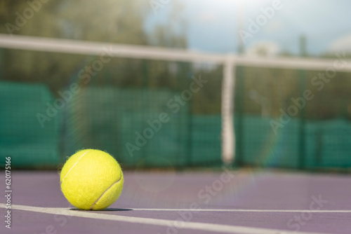 tennis background Close-up shots of tennis balls in tennis courts With a mesh as a blurred background And the light shining on the ground makes the image beautiful © Iliya Mitskavets