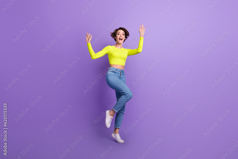 Full size photo of overjoyed cheerful girl raise hands dancing have good mood isolated on violet color background